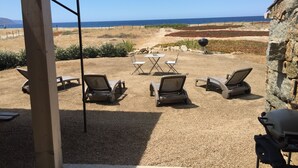 A patio area with outdoor seating, a grill, and a view of the ocean. - Charming sheepfold on the Liamone beach (Casaglione)