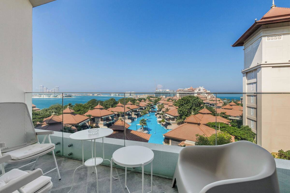 Een balkon met vrij uitzicht op het zwembad en de oceaan van een resort.