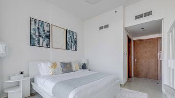 Une chambre à coucher moderne avec un grand lit, des tables de chevet et des œuvres d’art accrochées au mur.