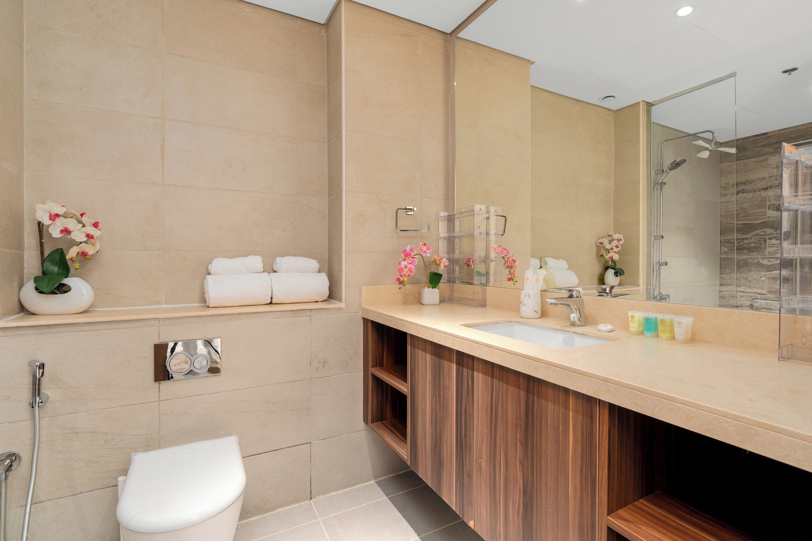 Een moderne badkamer met een grote spiegel, een wastafel, toilet en douche.