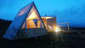 Una struttura a cupola geodetica con un ingresso triangolare e un piccolo balcone.