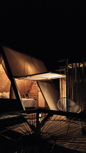 A tented accommodation with a bed, a chair, and a table. - Andes Glamping (Guatavita)
