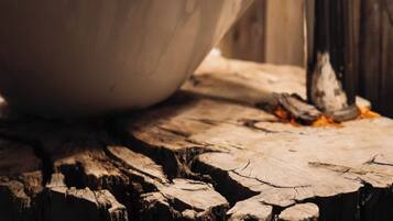 Un lavamanos de cerámica blanca con un grifo moderno, sobre una superficie de madera rústica.