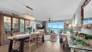 Una cocina amplia con comedor, ventanas grandes y vista al océano.