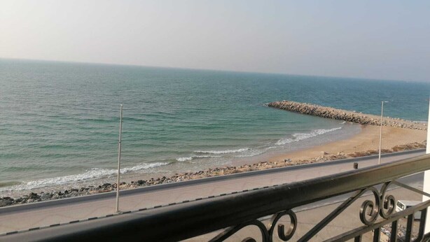 A beach with a rocky breakwater and a paved walkway along the shore. - Claridge Star Hotel (Ras Al Khaimah)