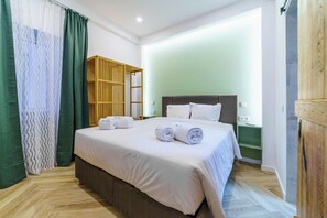 Relax in a cozy space with a neatly made bed, wooden wardrobe, and comfortable nightstand.