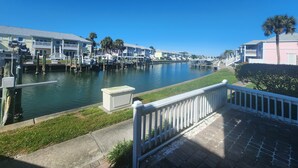 A marina with docked boats, a clear blue sky, and waterfront buildings.