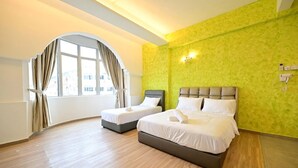 A hotel room with two beds, a large window with curtains, and a green textured wall. - First Star Homestay (Kluang)