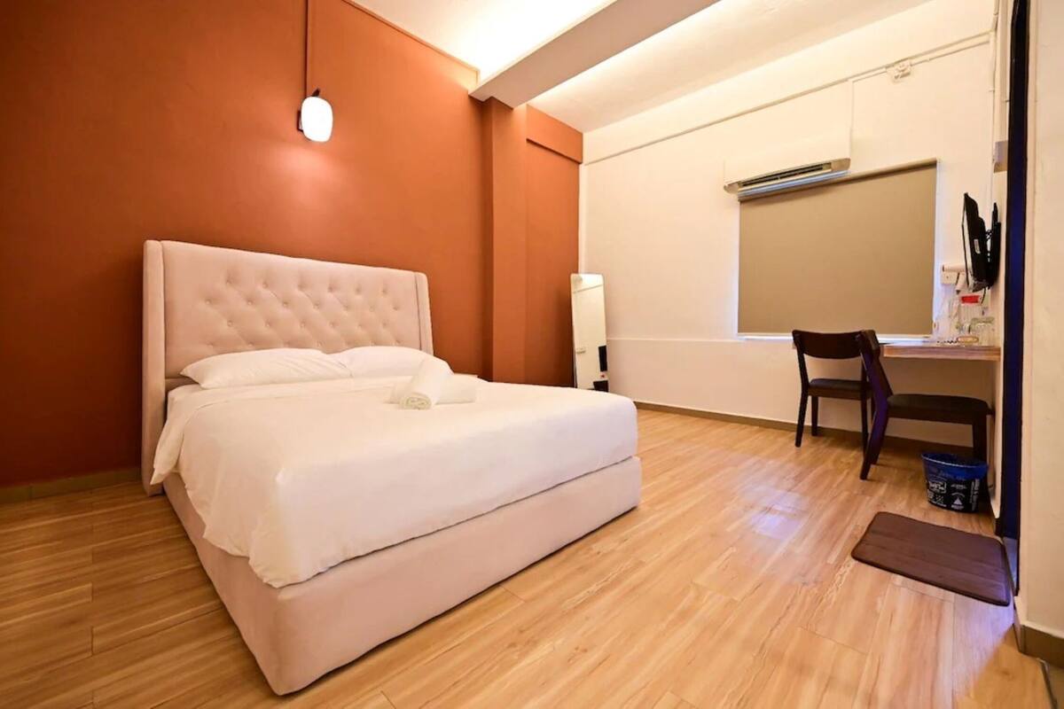 Une chambre avec un grand lit, un bureau et une chaise.