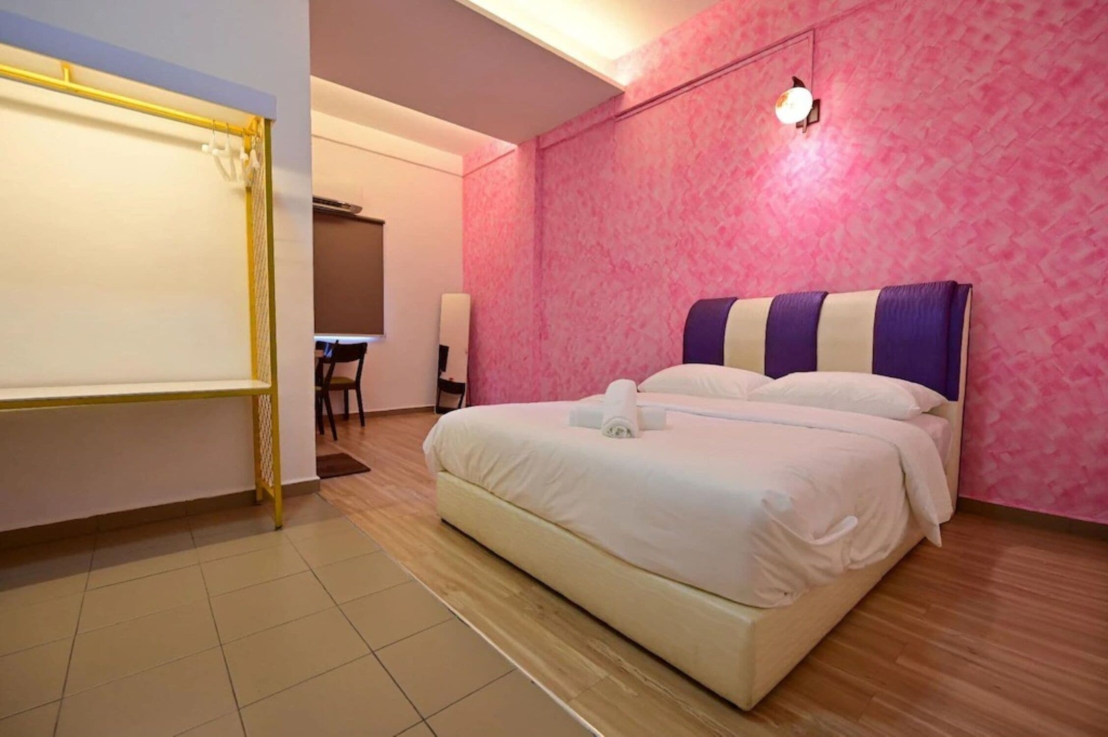 A hotel room with a large bed, a desk, and a chair.
