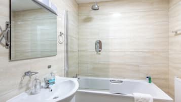 A bathroom with a sink, mirror, shower, and bathtub.