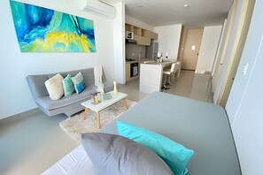 Un salon moderne avec un canapé, une table basse et un tableau accroché au mur.