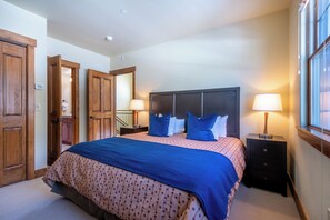 Ein Schlafzimmer mit einem großen Bett, einem Holzschrank und einem Nachttisch mit Lampe.