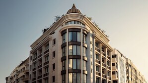 Un hotel de varios pisos con una cúpula destacada en la parte superior y amplias ventanas.
