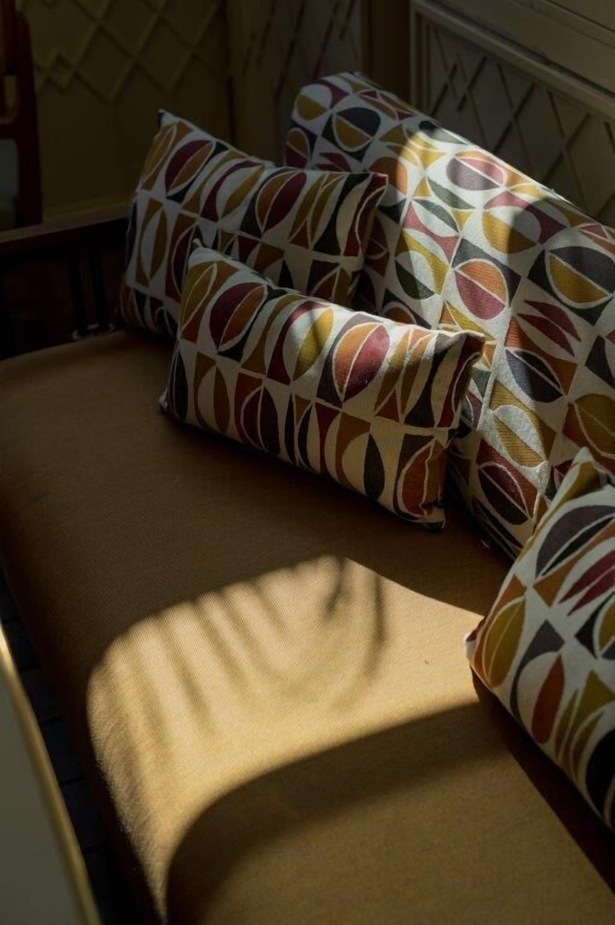 A bed with patterned pillows and a light-colored headboard.