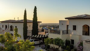 A residential area with two-story houses, a car parked under a covered area, and a clear view of the surrounding neighborhood. - Perfect Getaway for 2 With Shared Pool (Kouklia)