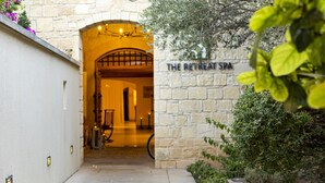 A stone entrance to The Retreat Spa with a warm interior and a sign on the wall. - Perfect Getaway for 2 With Shared Pool (Kouklia)