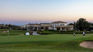 A golf course with a clubhouse and residential buildings in the background. - Perfect Getaway for 2 With Shared Pool (Kouklia)