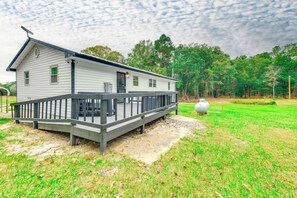 A white house with a wooden deck and a large white vase in the yard. - The Country Oasis: Near ASU, Tuskegee & Auburn (Shorter)