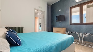 A bedroom with a bed, a radiator, a TV mounted on the wall, and a window with blinds. - 4215 Villa I Doni Della Luna by Barbarhouse (Porto Cesareo)
