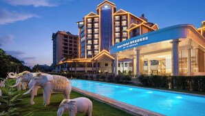 A hotel with a swimming pool, large columns, and a sign in a foreign language. - Days Hotel By Wyndham Xishuangbanna Jinghong (Xishuangbanna Dai)