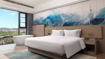 A modern hotel room with a large bed, a view of the city, and a unique wall mural.