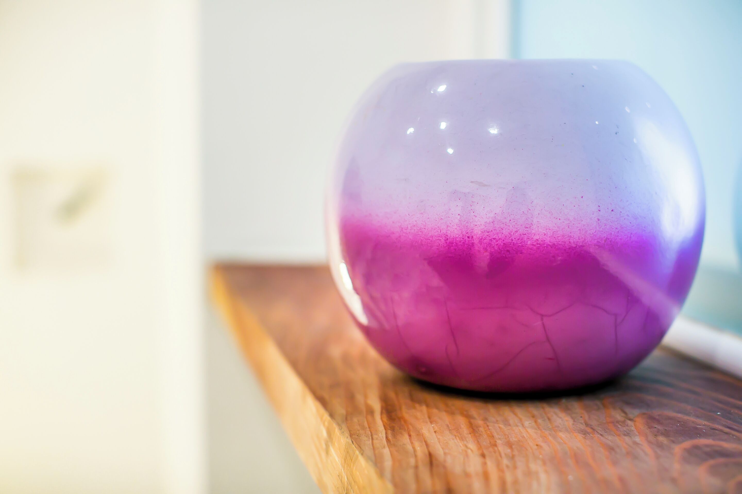 A purple vase on a wooden surface.