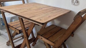 A wooden table with chairs in a room with white walls and a telephone mounted on the wall. - 2Next Confins Airport, Cid Galo, 15minBH, Mega Space  (Centro Vespasiano)