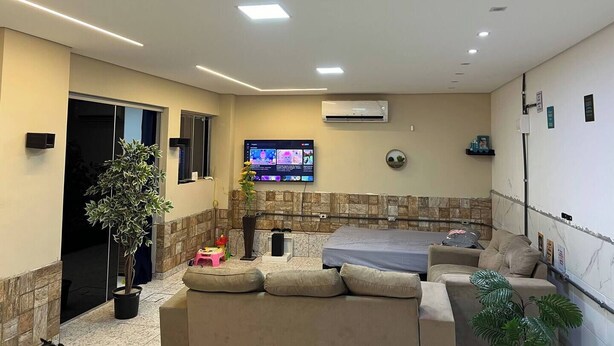 Una sala de estar moderna con un sofá, un televisor y una pared de acento de piedra.