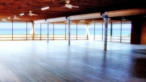 An open wooden deck with ceiling fans, large windows, and a view of the sea. - *Aug 29 - Sept 2 Open * End of Summer Getaway!* (Panama City Beach)