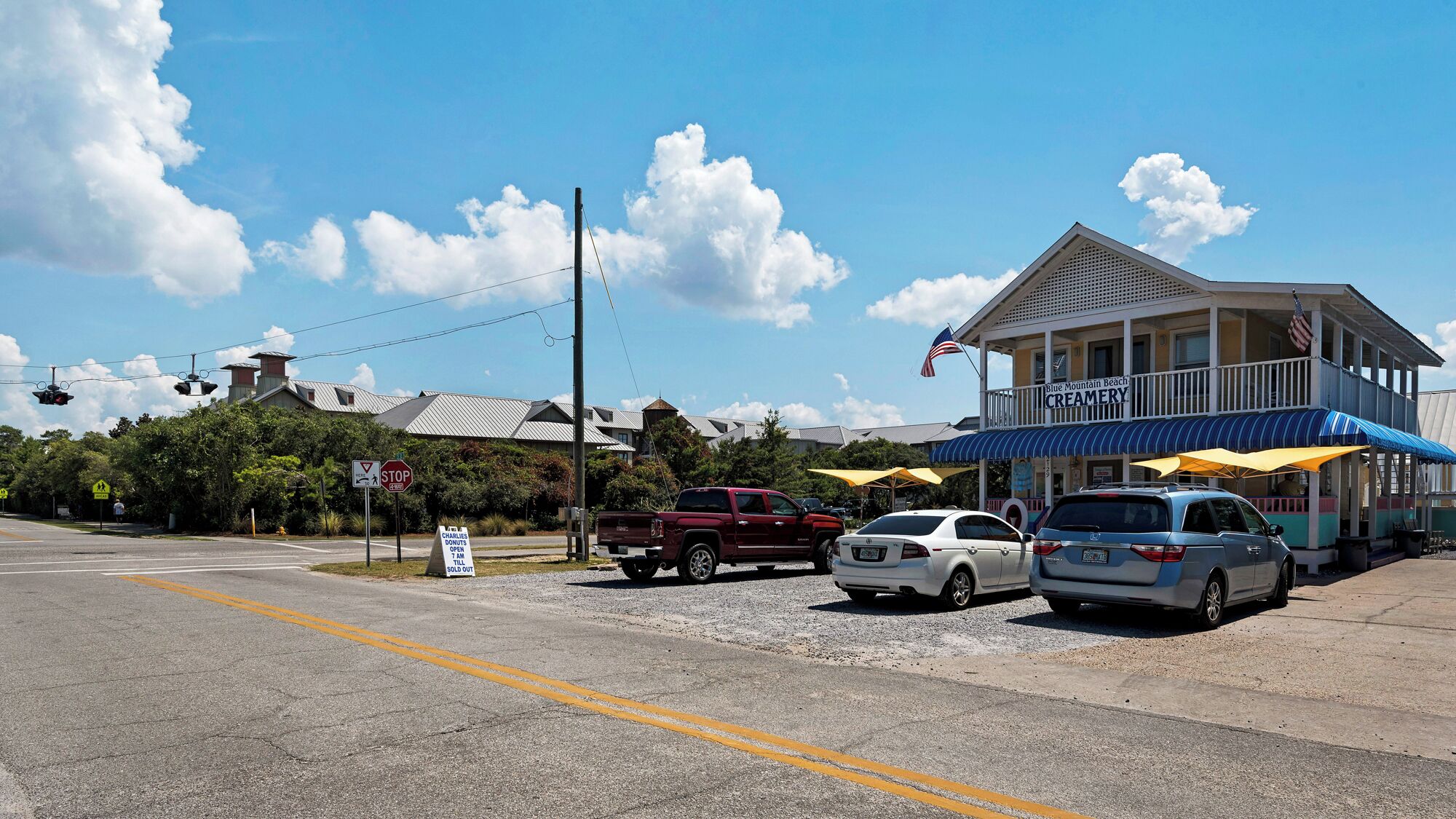 A beachfront building with a blue awning and a sign for Blue Mountain Beach Creamery.