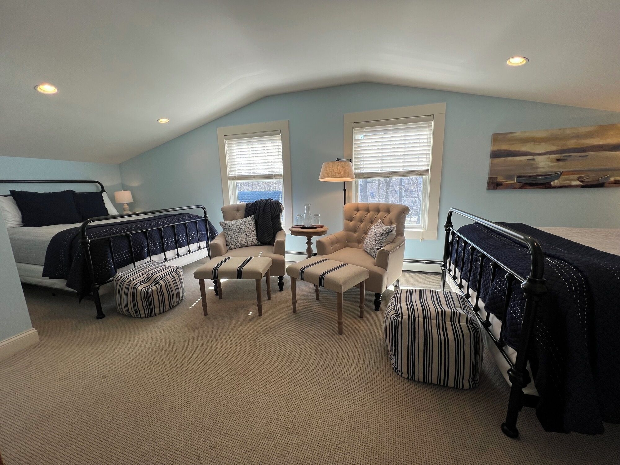 A bedroom with a bed, a chair, a table, and a window.