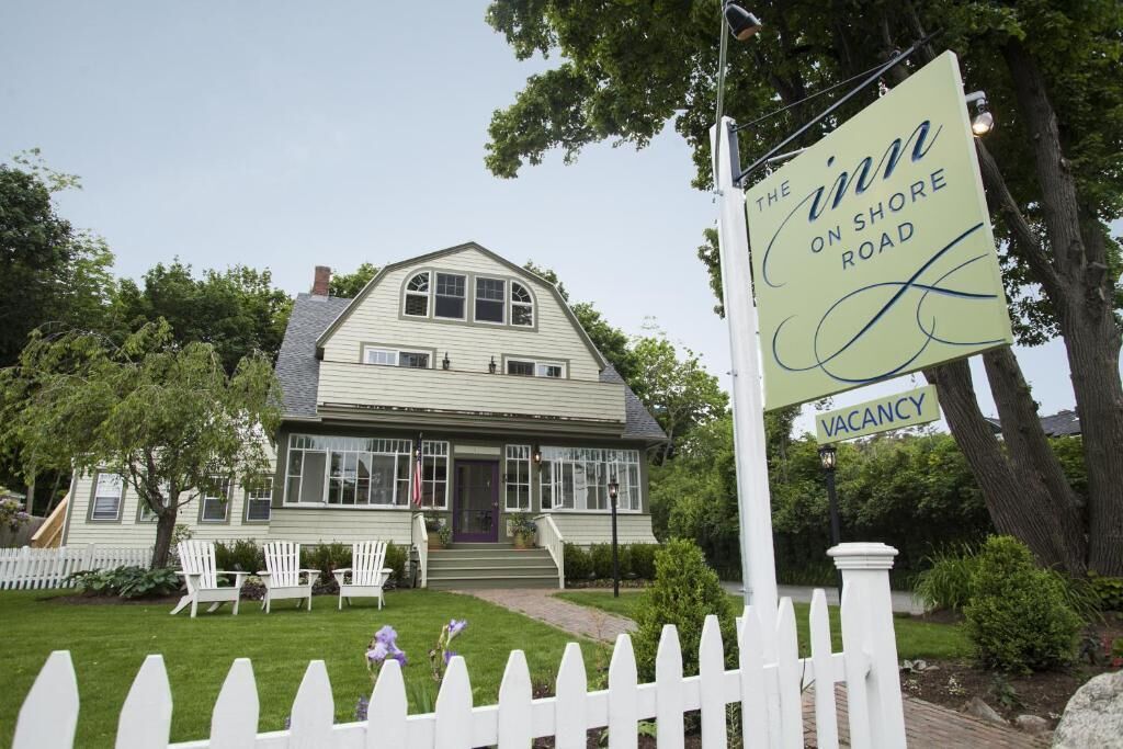 A two-story house with a porch, a sign indicating 'The Inn on Shore Road' and 'Vacancy'.