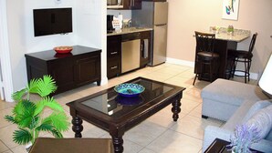 Un espace de vie compact comprenant une cuisine, un coin repas et un espace détente.