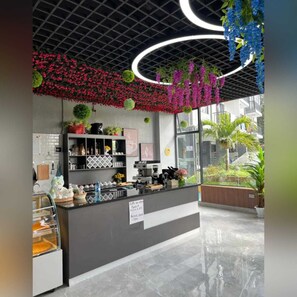 Enjoy a warm cup of coffee at this inviting coffee shop with a large window offering a view of the outside.