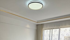 Ein modernes Schlafzimmer mit einem großen Bett, einer Kopfteil und Blick ins Freie durch ein Fenster.