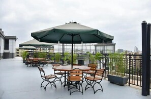Relax in the shaded patio area with a wooden table and comfortable seating for four.
