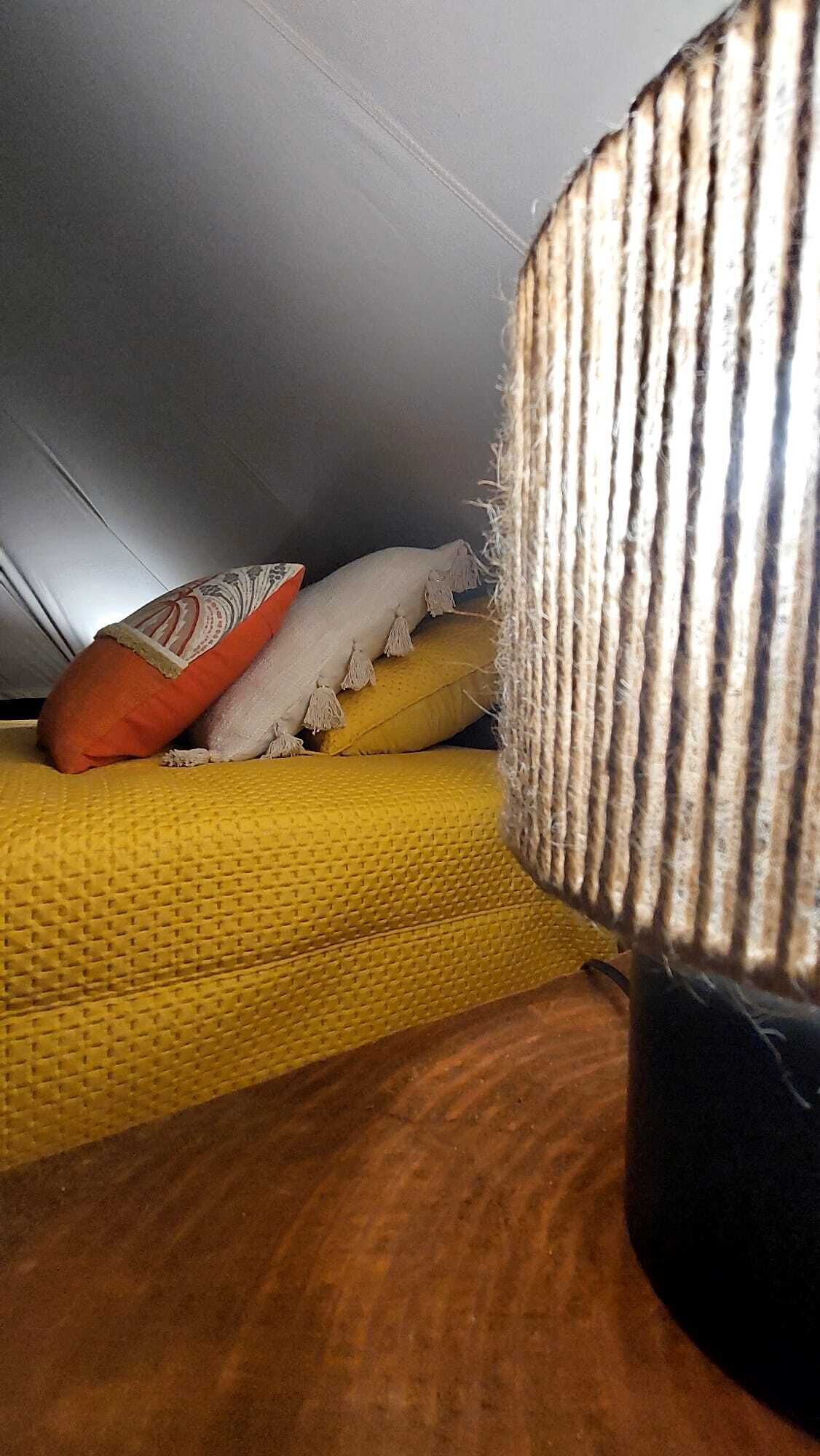 Un gros plan d’un tissu texturé, peut-être un rideau ou un revêtement, présentant une texture rugueuse rappelant celle d’une corde.