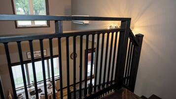 A staircase with a black railing leading to a dining area with a table set for two.