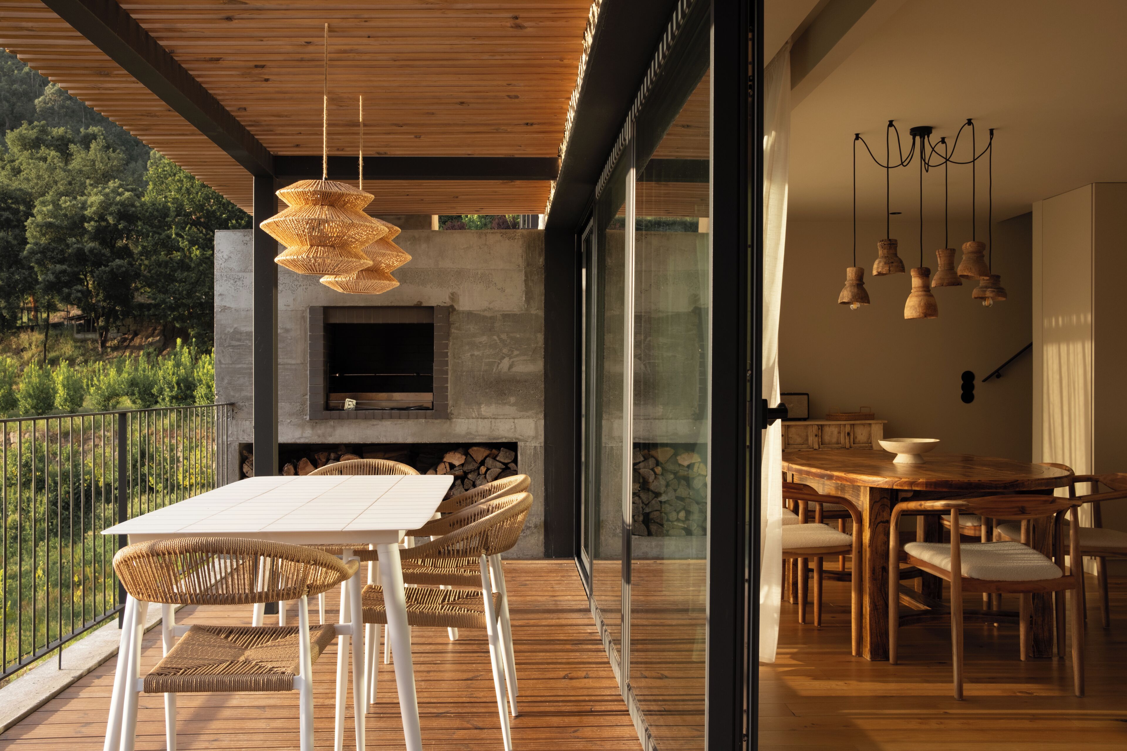 An outdoor patio with a dining table, chairs, a TV, and a fireplace.