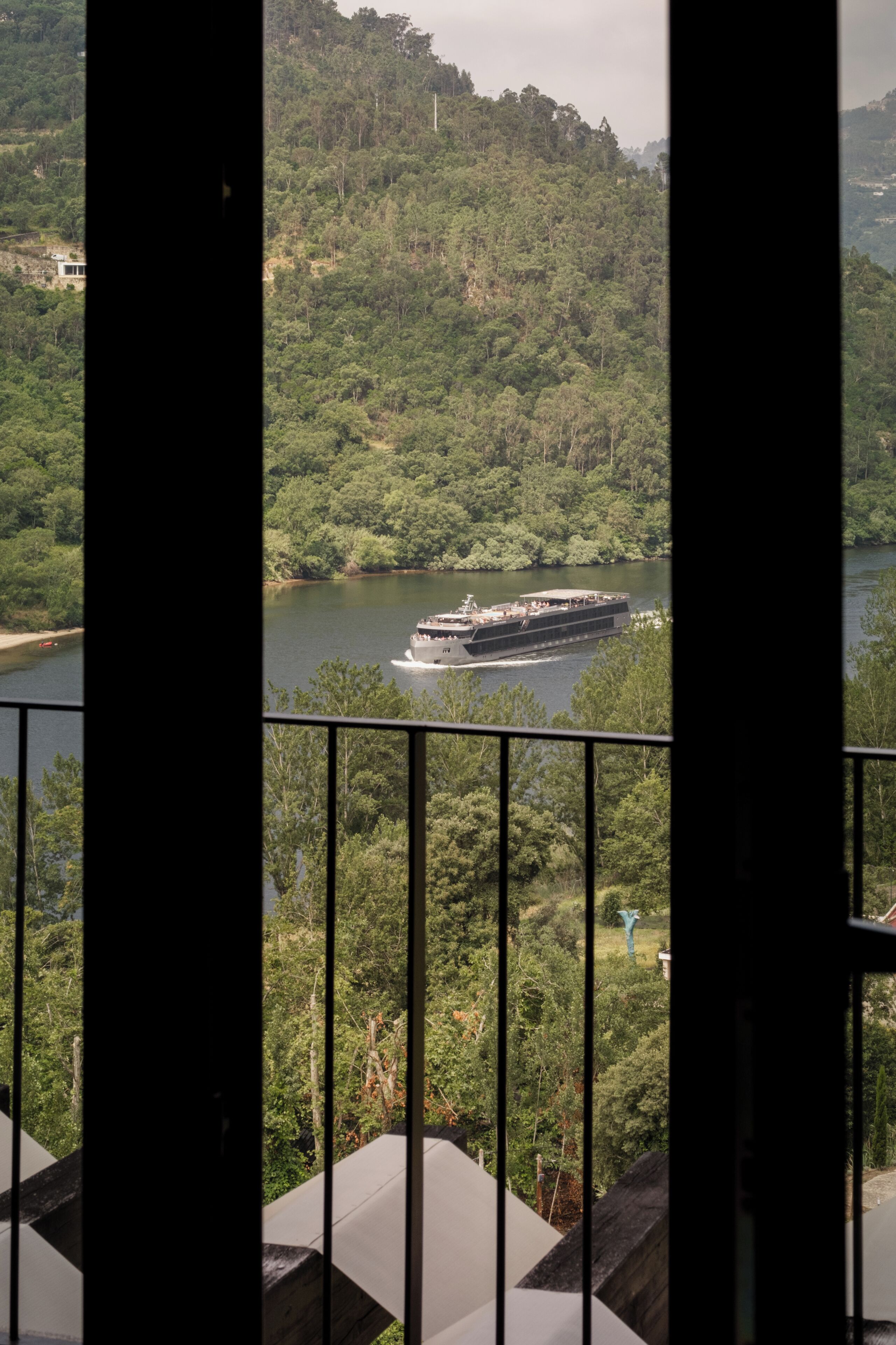 A river view from a balcony with a boat on the water.
