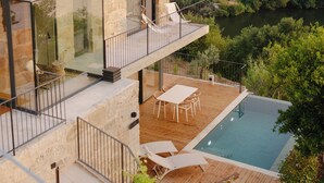 A modern house with a glass balcony, a swimming pool, and a view of a forested hillside. - Dajas Douro Valley – New opening (Marco de Canaveses)