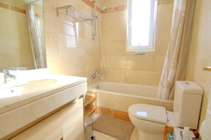 A bathroom with a sink, toilet, and bathtub.