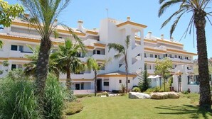 A multi-story hotel with a white facade and yellow accents, surrounded by palm trees and well-maintained lawns. - CT 100 - Antes Penthouse (Mijas)