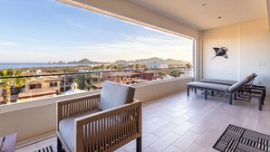 En balkong med utsikt över havet och bergen, möbler i rotting och en modern design.