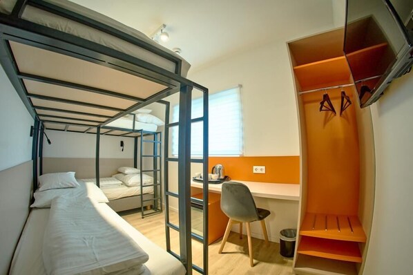 Une chambre de dortoir avec des lits superposés, un bureau et une chaise.