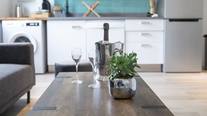 Een moderne keuken met een houten tafel, een potplant, een wijnglas en een fles champagne.