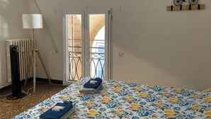 A bedroom with a bed, a radiator, a lamp, and a bicycle decoration on the wall.