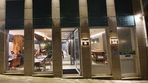 A restaurant with a modern interior, visible seating arrangements, and a welcoming entrance. - 7 Bridges Estúdios (Porto)