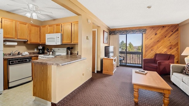 Un espacio habitable compacto con kitchenette, comedor y balcón con vistas.